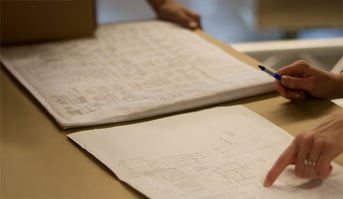 Hands arranging documents, suggesting an administrative or organizational task.