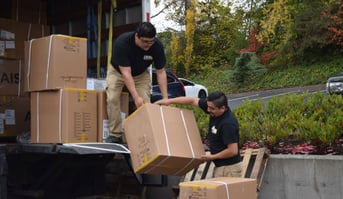 Movers loading boxes into a truck, indicating a moving or relocation activity.