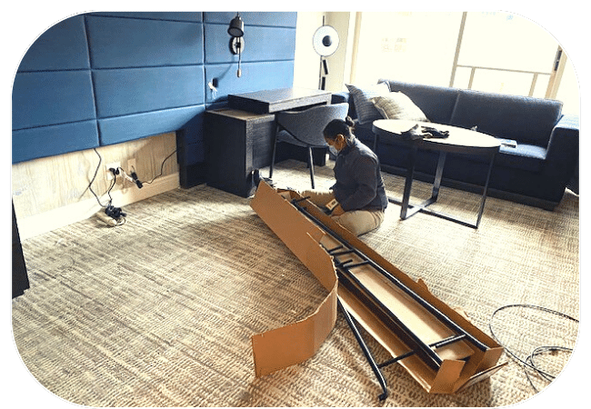 A person assembling a piece of furniture in an office environment.
