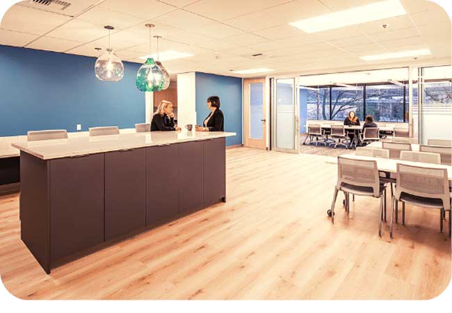  An open-concept office space with a reception desk, chairs, and other furniture. 